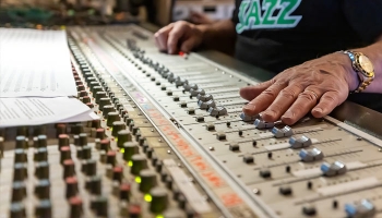 Hands maneuvering an audio control board