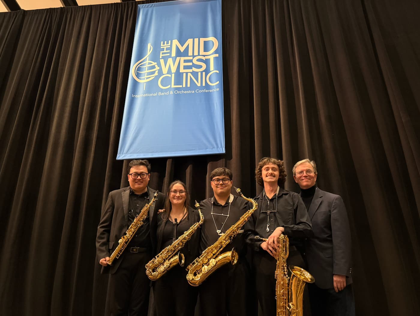 Four saxophonist pose with Dr. Eric Nestler at the Midwest Clinic in Chicago