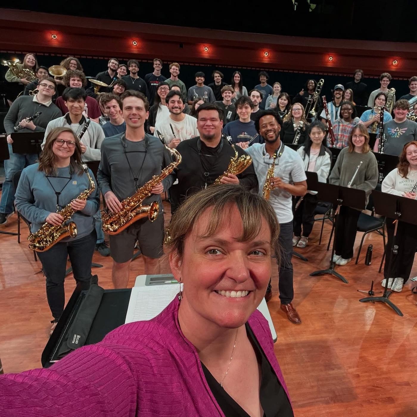 Members of the Lotus Saxophone Quartet and Dr. Amy Woody pose with the UNT Wind Ensemble following a rehearsal