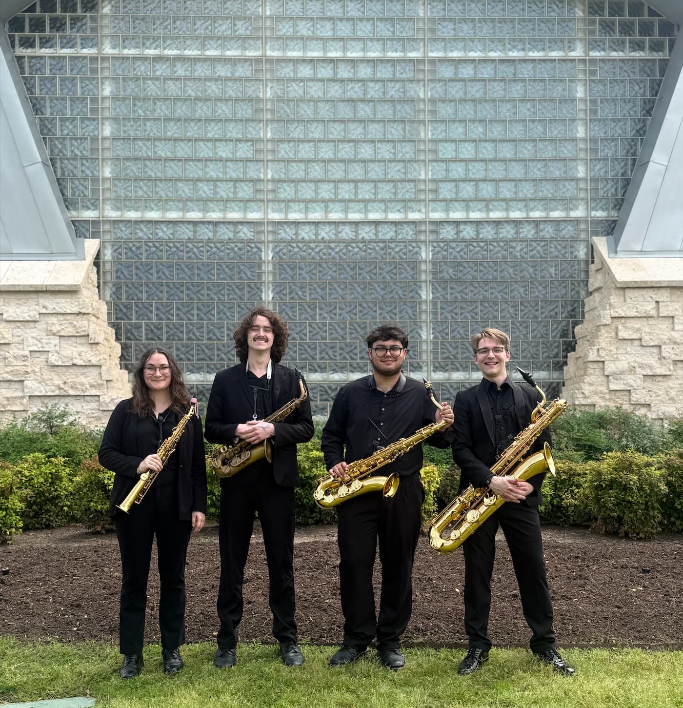 The Wind Symphony saxopone section poses infront of the Murchison Performing Arts Center before a concert