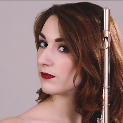 Image shows student holding her flute upright on her left side as her head is turned to the right. 