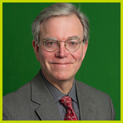 Image shows Dr. Nestler facing the camera smiling wearing a gray sport coat and a gray shirt with thin white lines. He is also wearing a maroon patterned tie. Dr. Nestler wears eyeglasses that are gold rimmed.