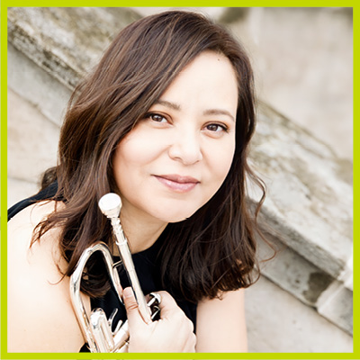 Image shows Dr. Samayoa looking to the camera holding a trumpet in her right hand wearing a black outfit.