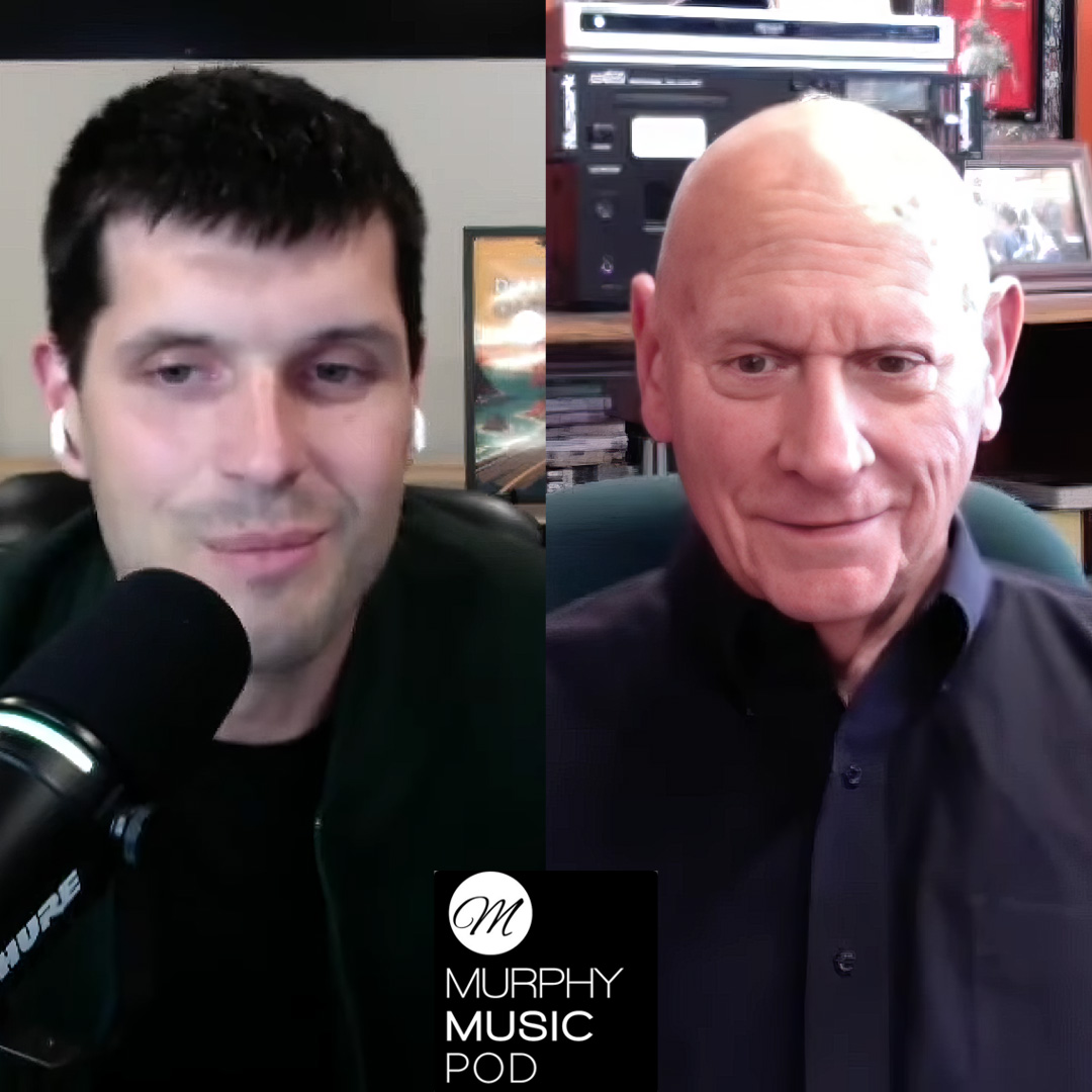 Sean Murphy, left, is sitting at a microphone, has black hair and is wearing a black shirt. Professor Corporon, right, is smiling and wearing a dark-colored shirt.