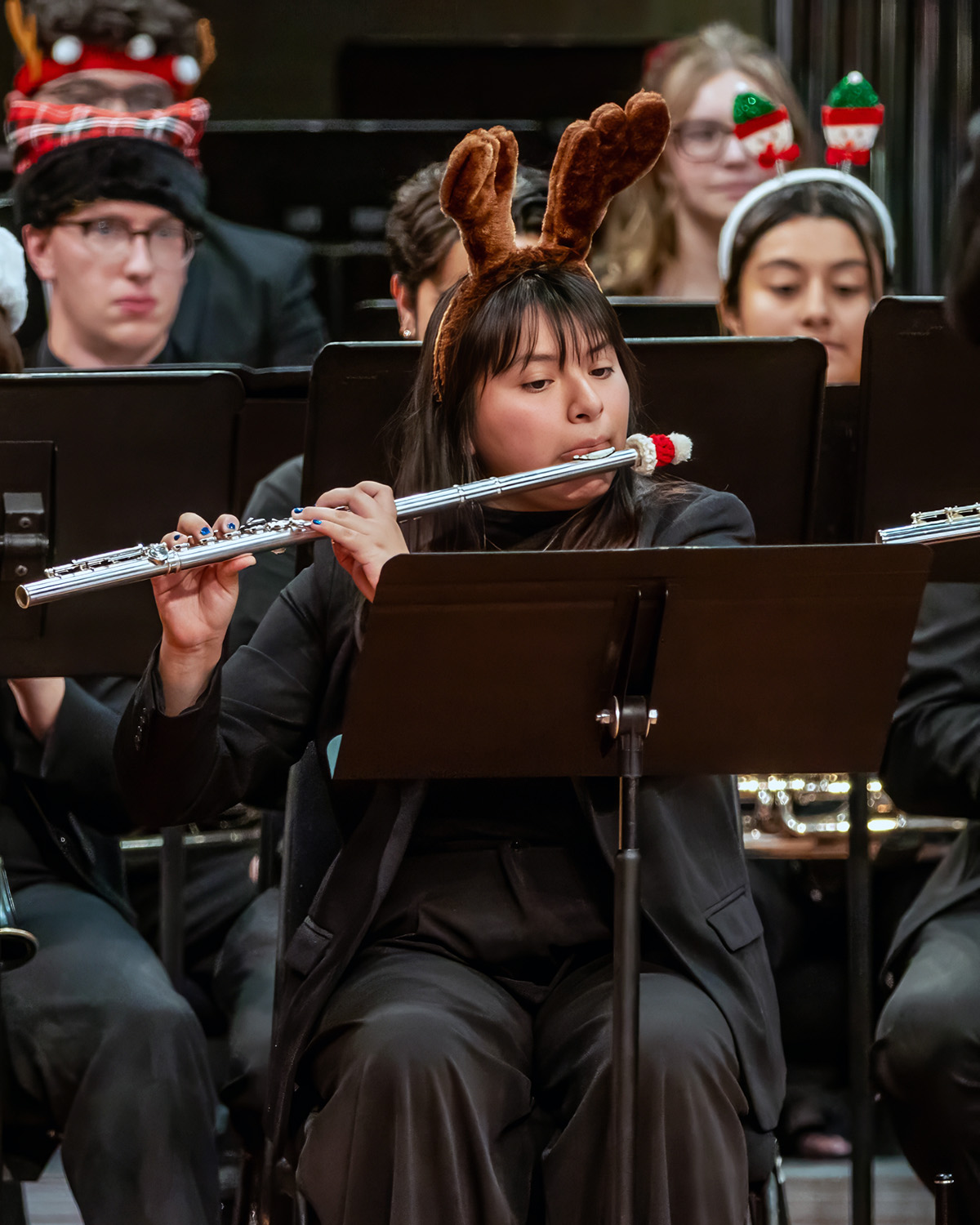 Flute player performing, seated, wearing reindeer antlers
